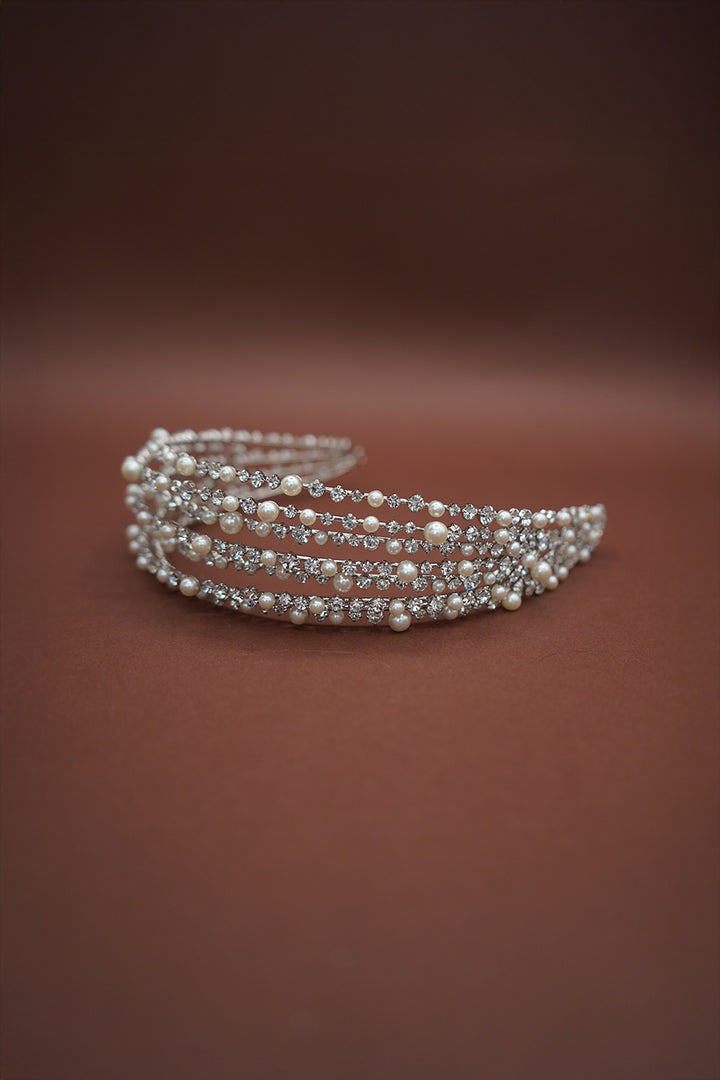 Silver bracelet with pearls on a brown background